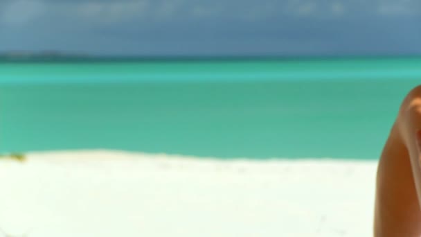 Elegant young female relaxing on white sandy beach looking at aquamarine waters — Stock Video