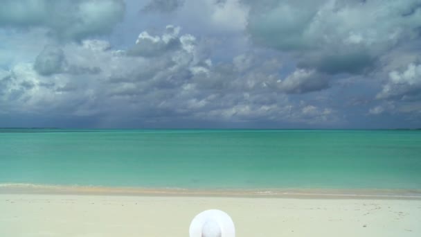 Serena joven mujer tomando el sol y soñando bajo nubes tropicales — Vídeos de Stock