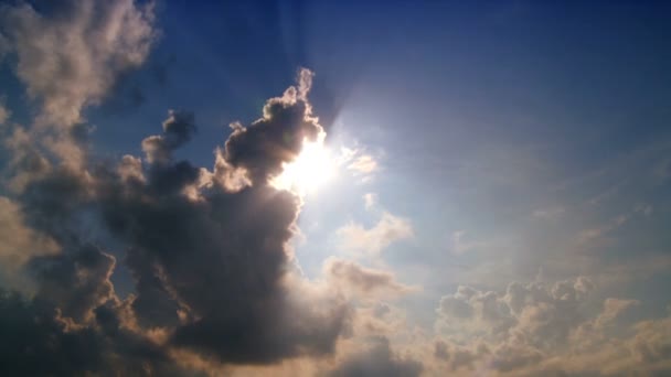 Nuvens grossas que se movem através do sol e céu azul profundo — Vídeo de Stock