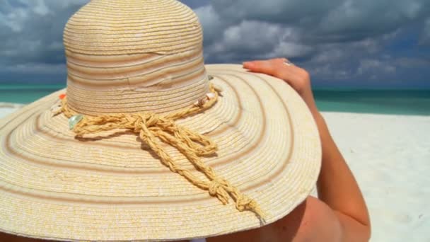 Elegante giovane donna rilassante sulla spiaggia di sabbia bianca guardando le acque dell'acquamarina — Video Stock