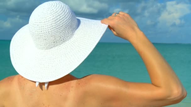Голова и плечи элегантной молодой женщины, смотрящей на тропический океан аква-цвета — стоковое видео