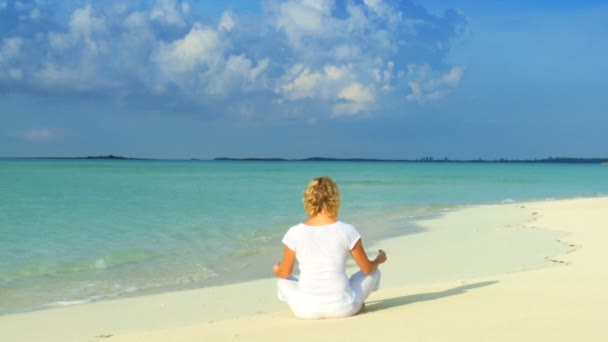 Ruhige junge Frau entspannt sich mit Yoga an einem wunderschönen tropischen Strand — Stockvideo