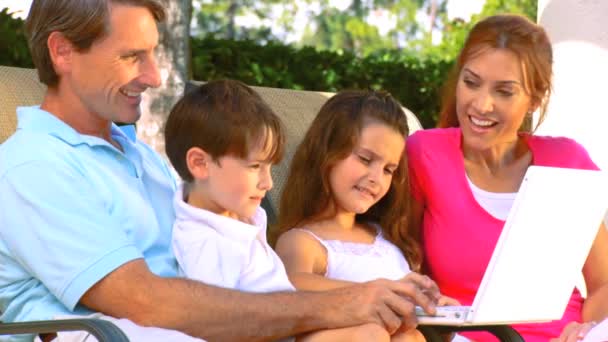 Atractiva familia joven caucásica usando una computadora portátil al aire libre para hacer planes futuros — Vídeo de stock