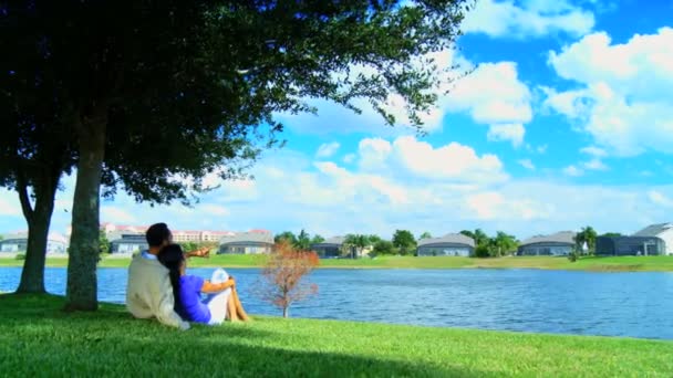 Jeune couple afro-américain relaxant au bord d'un lac planifiant leur futur mode de vie — Video