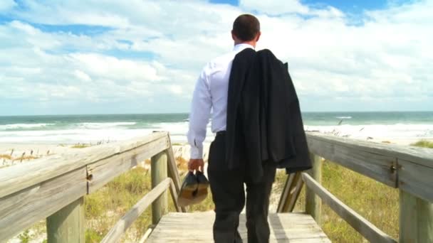 Slimme jonge zakenman time-out te nemen van het kantoor op het strand — Stockvideo
