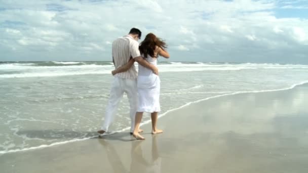 Attraktive junge kaukasische Lieblinge, die gemeinsam am Strand spazieren gehen — Stockvideo
