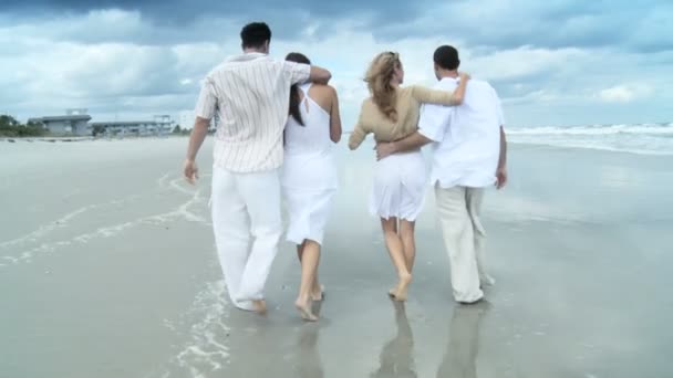 Quatre jeunes amis adultes attrayants s'amusent sur la plage ensemble — Video