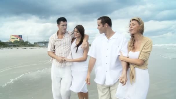 Cuatro atractivos amigos adultos jóvenes que se divierten juntos en la playa — Vídeos de Stock