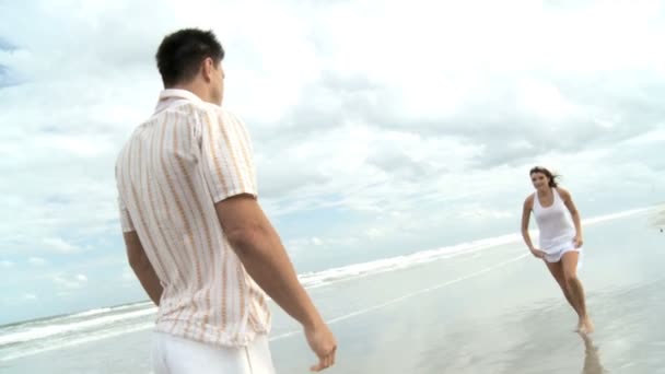 Двое влюблённых молодых безумно веселятся на пляже — стоковое видео