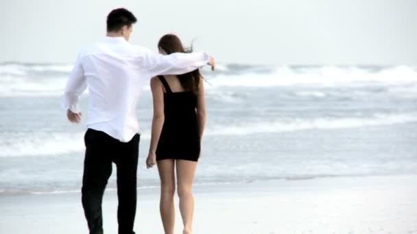 Zwei junge verliebte Spaziergänge am Strand nach einer geselligen Nacht — Stockvideo