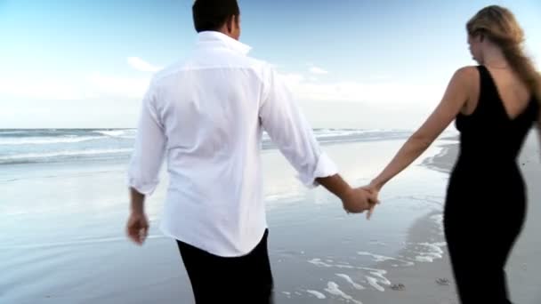 Dos jóvenes enamorados divirtiéndose en la playa temprano en la mañana después de una noche social — Vídeos de Stock