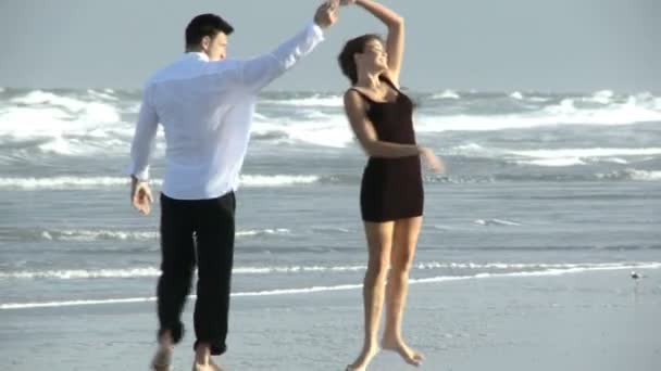 Dos jóvenes enamorados divirtiéndose en la playa temprano en la mañana después de una noche social — Vídeos de Stock