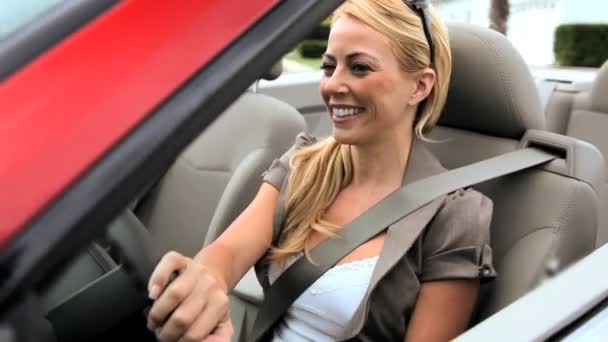 Successful young businesswoman enjoying the sunshine while driving her luxury open top car — Stock Video