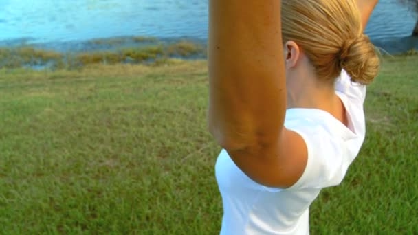 Beautiful young blonde girl enjoying breathing relaxation exercises outdoors — Stock Video