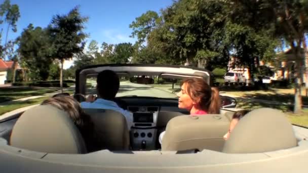 Aantrekkelijke Kaukasische familie genieten van rijden huis in de zon in hun open top auto — Stockvideo