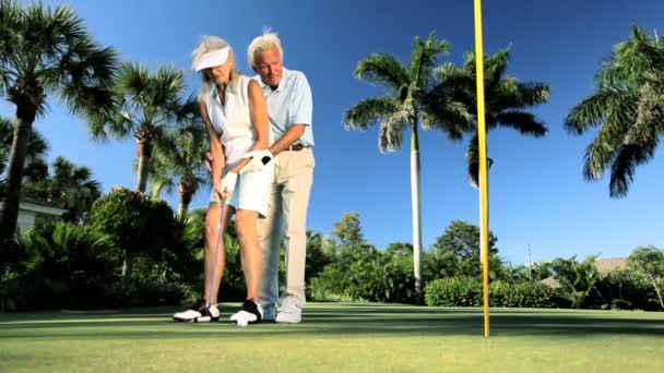 Senior koppel beoefenen van golf — Stockvideo