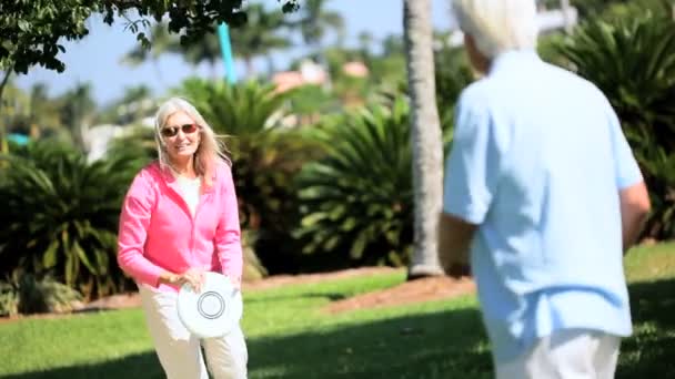 Senioren plezier met een frisbee — Stockvideo