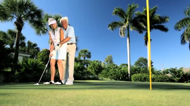 Idosos aprendendo a jogar golfe — Vídeo de Stock