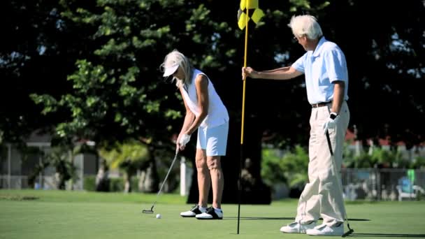 Adultos mayores saludables disfrutando del golf — Vídeo de stock