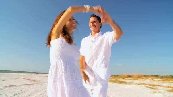 Смеющаяся парочка танцует на пляже — стоковое видео