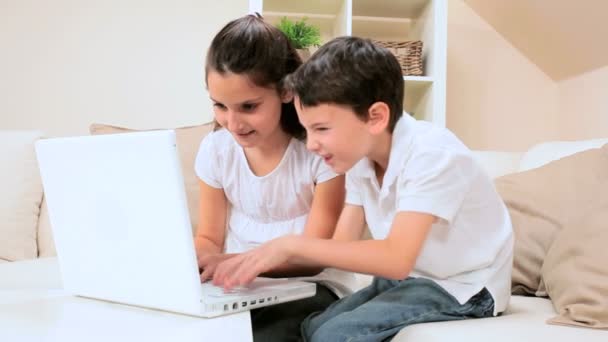 Niños caucásicos usando el ordenador portátil en casa — Vídeo de stock