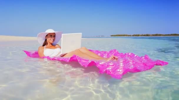 Caucasian Female Floating in the Ocean Using Laptop — Stock Video