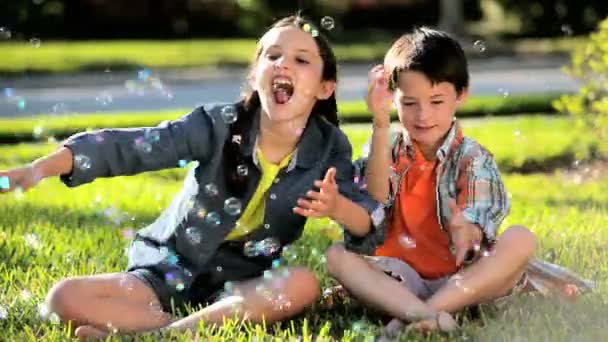 Двоє дітей на відкритому повітрі з грати бульбашки — стокове відео