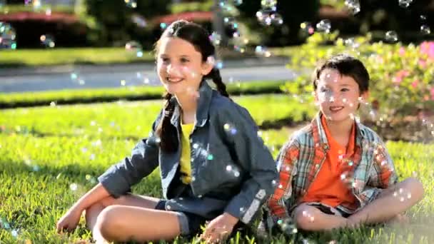 Jonge kinderen en wordt omringd door spelen bubbels — Stockvideo