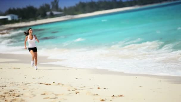 Gezonde Kaukasische vrouwelijke joggen op tropisch strand — Stockvideo