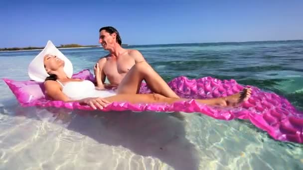 Ελκυστικό ζευγάρι στον ωκεανό με αερόστρωμα — Αρχείο Βίντεο