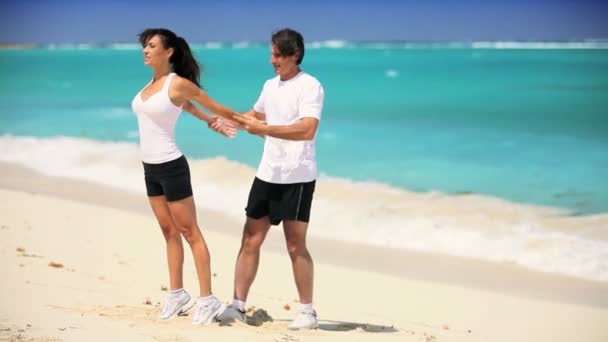 Jeune couple en vêtements de sport s'exerçant sur la plage — Video