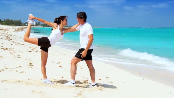 Здоровые пары упражнения на пляже — стоковое видео