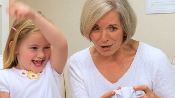 Linda chica y abuela jugando juegos electrónicos — Vídeo de stock