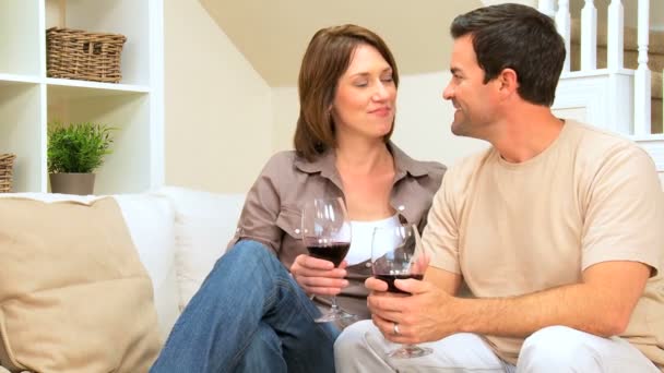 Молодая пара пьет вино дома — стоковое видео