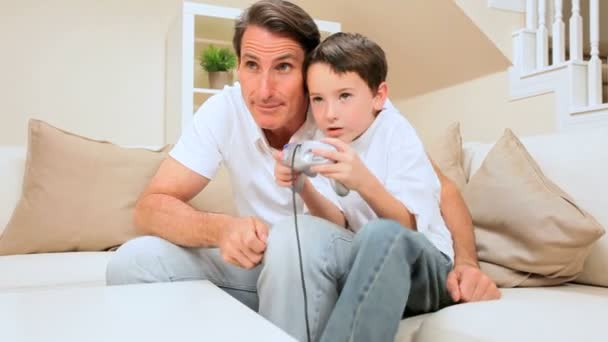 Отец и сын играют в игровую приставку — стоковое видео