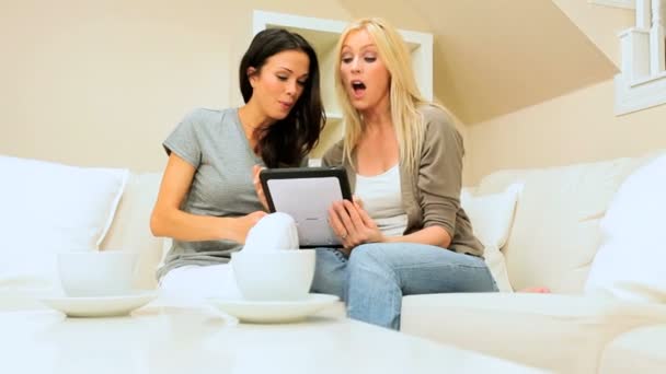 Amigos muito femininos usando tablet sem fio em casa — Vídeo de Stock