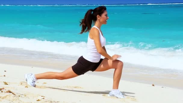 Mince jeune femme faisant des étirements sur la plage — Video