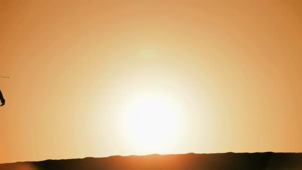 Μοναχική γυναίκα σε σιλουέτα, πεζοπορία σε αμμόλοφους & βλέποντας τον ήλιο να δύει — Αρχείο Βίντεο
