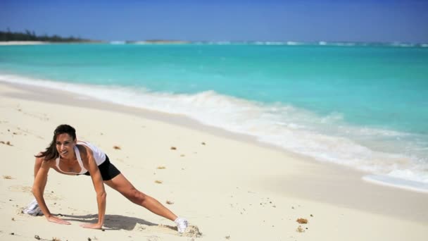 Hembra saludable haciendo estiramientos en la playa — Vídeos de Stock