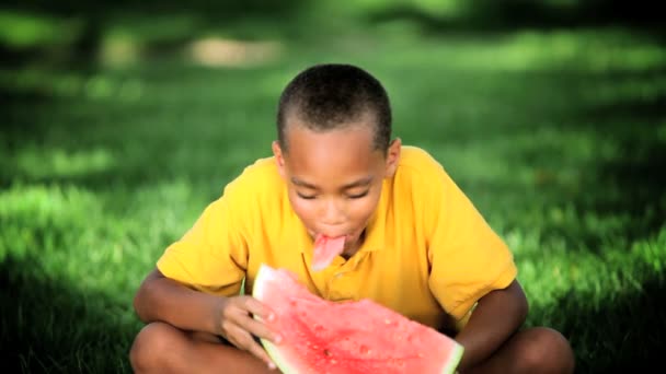 Etnische jongen eten gezond water meloen — Stockvideo