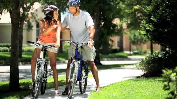 Νεαρό υγιή εθνική ζευγάρι ποδηλασία μαζί — Αρχείο Βίντεο