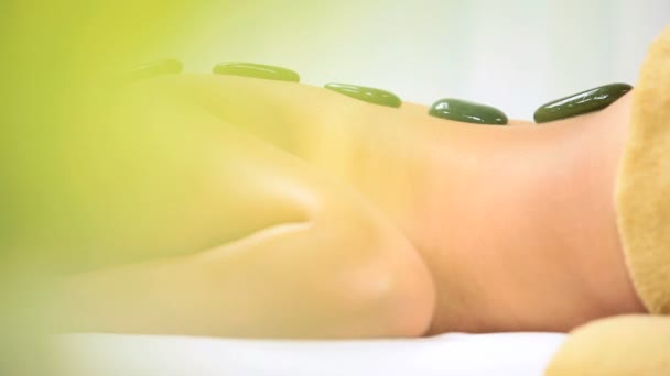 Jonge spa client ontspannen met hete stenen therapie — Stockvideo