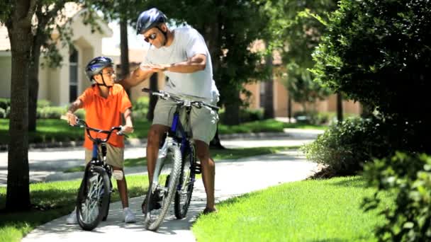 Этнический отец и сын на велосипедах — стоковое видео