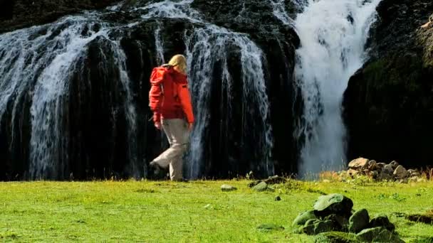 Jeune randonneur regardant une cascade — Video