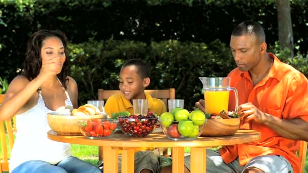 junge ethnische Familie teilt ein gesundes Mittagessen im Freien