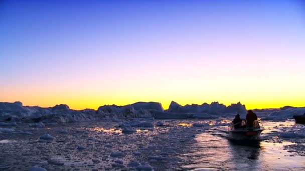 Σκάφη στο ηλιοβασίλεμα σε όγκους πάγου με τα παγόβουνα — Αρχείο Βίντεο