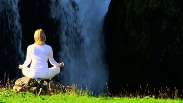 Mädchen praktiziert Yoga am Wasserfall — Stockvideo