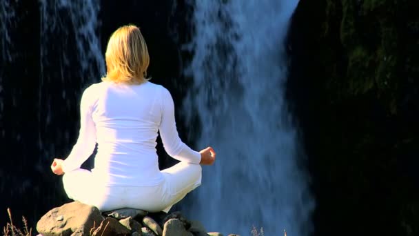 Meisje praktiserende yoga door waterfall — Stockvideo