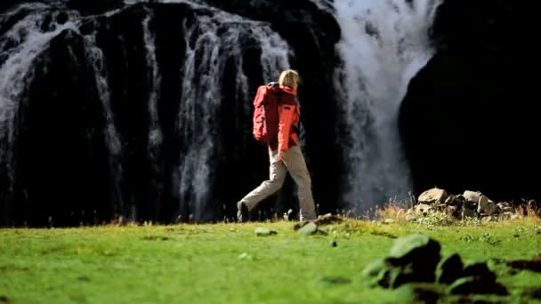 Eenzame vrouw op expeditie wandelen door waterfall — Stockvideo