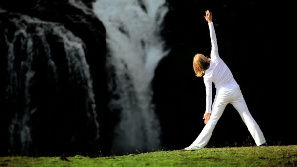 Mädchen praktiziert Yoga am Wasserfall — Stockvideo